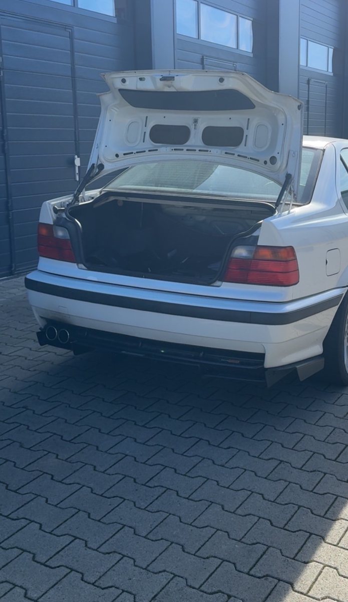 Aktueller Heckblick des weißen BMW E36 mit geöffnetem Kofferraum